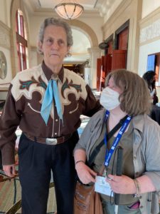 An unmasked Temple Grandin standing next to Carin...who is still in a mask